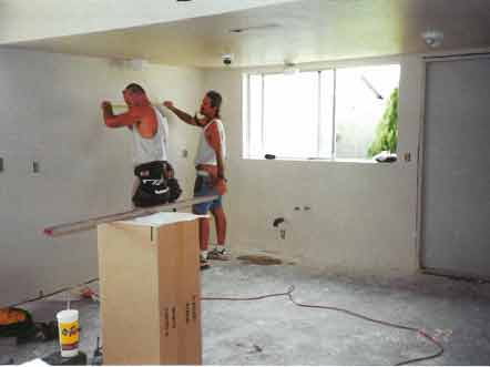 Kowalski crew hanging new kitchen cabinets after mold remediation